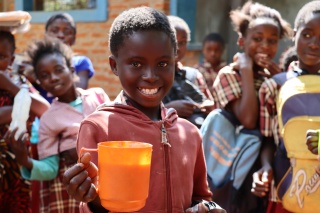 Child smiling with a mug