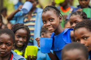 Children smiling and holding mugs