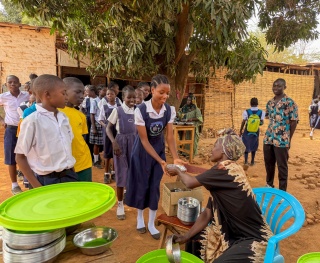Aishia and students receiving food
